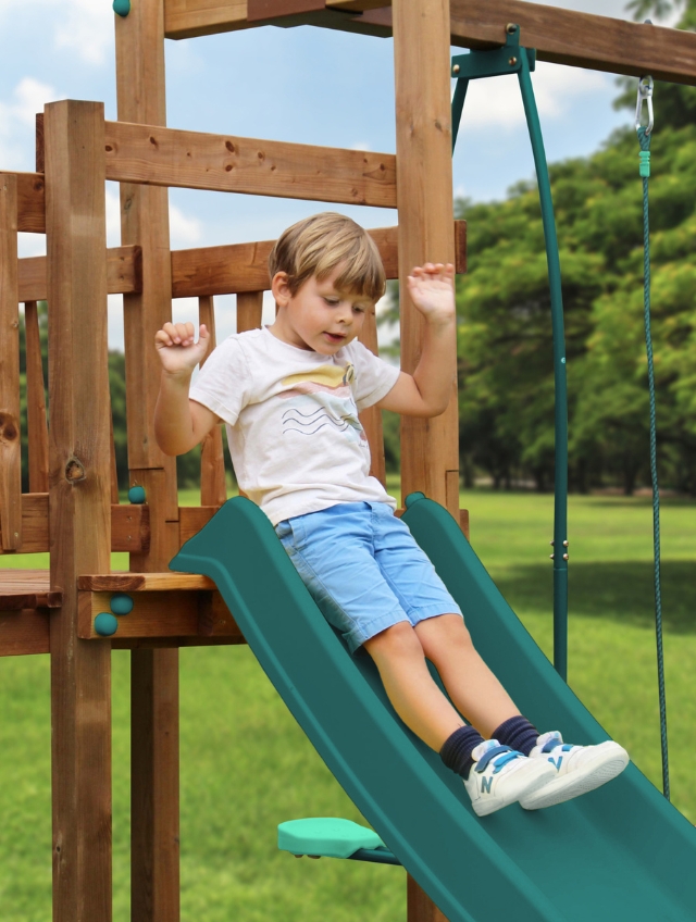 Enfants jouant et grimpant sur une aire de jeux en bois dans un jardin